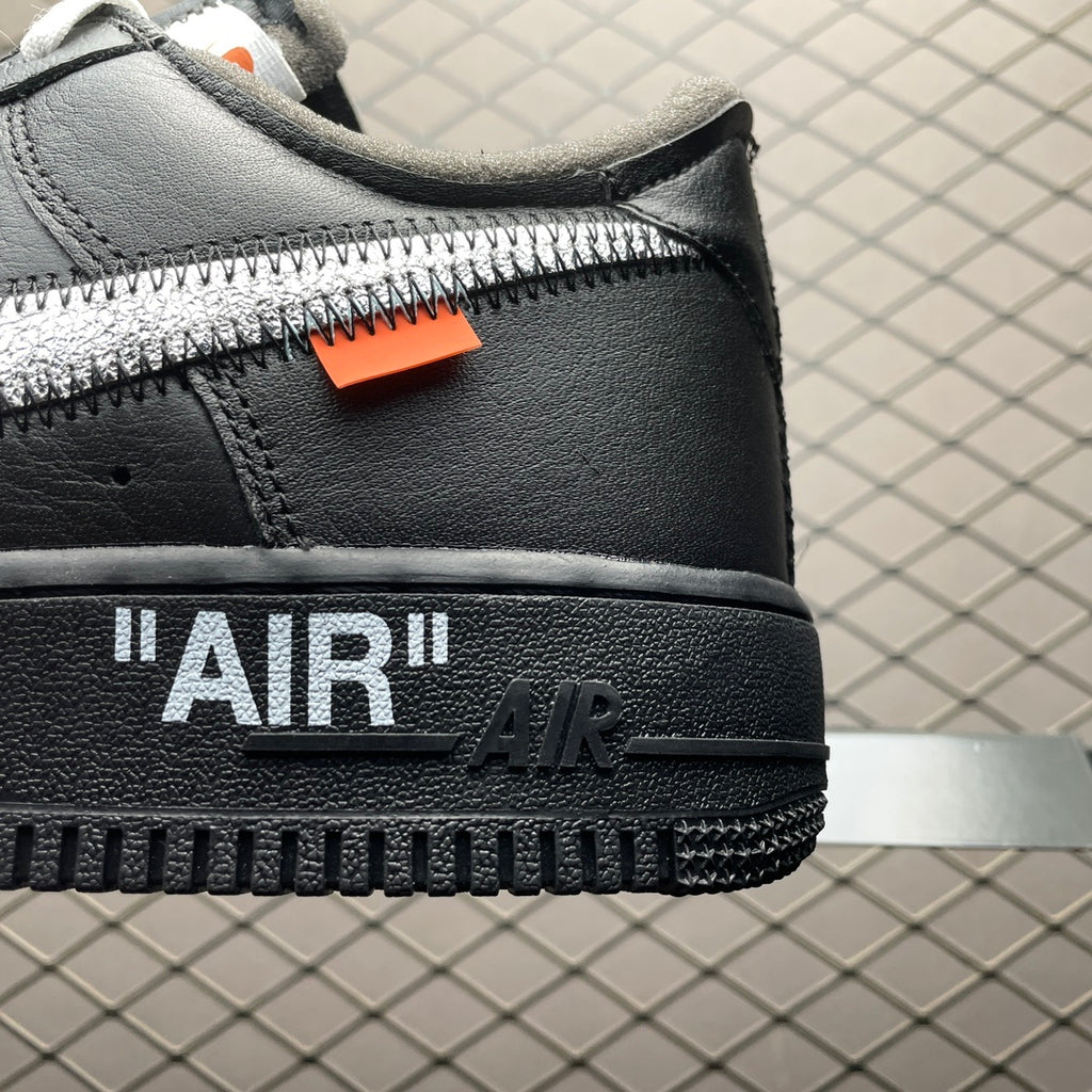 Black sneaker back detail with orange tag and "AIR" logo on the heel