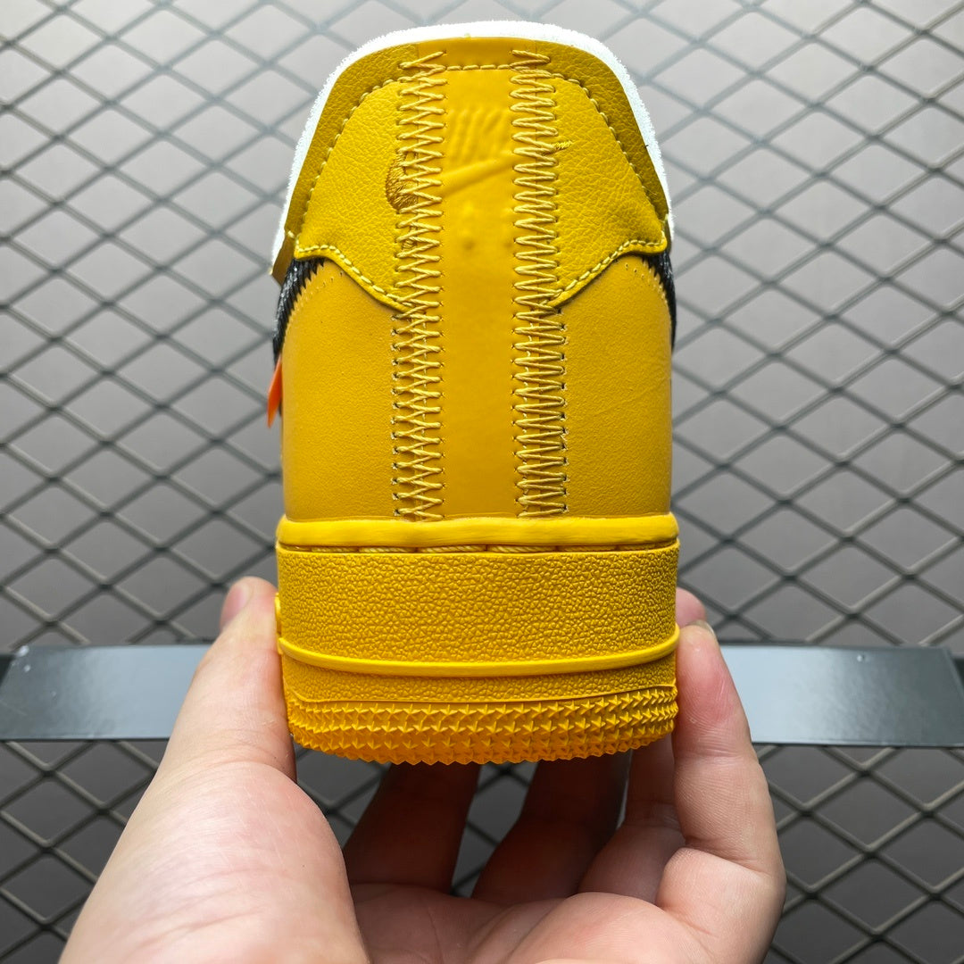 Yellow Air-style sneakers shown from the heel with woven laces and rubber sole