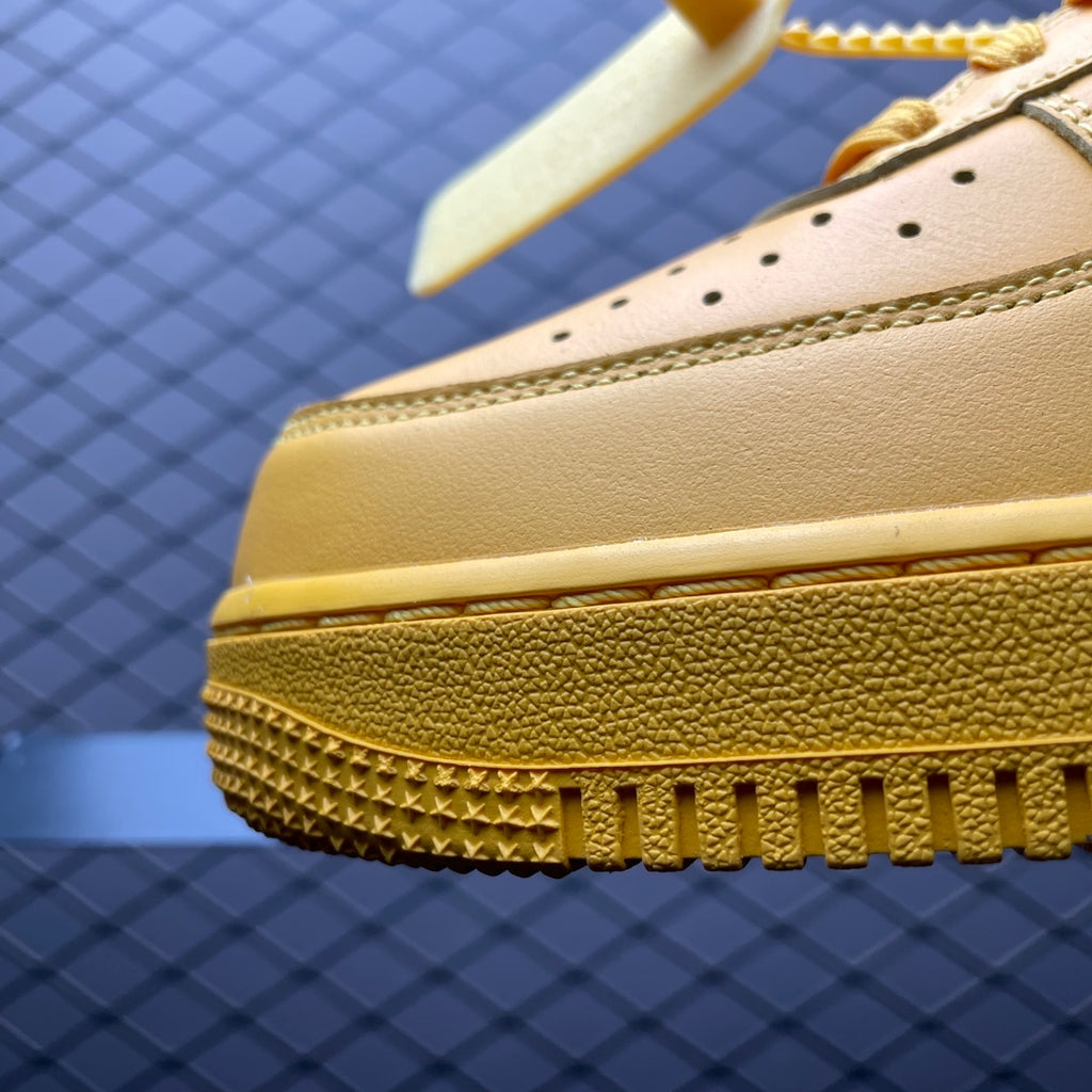 Yellow leather sneaker toe with textured sole edge and small perforation holes