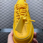 Yellow low-top sneakers with yellow laces, perforations, and Swoosh on side