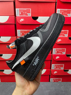 Black low-top mesh sneaker with white swoosh panel and black lace-up, side view
