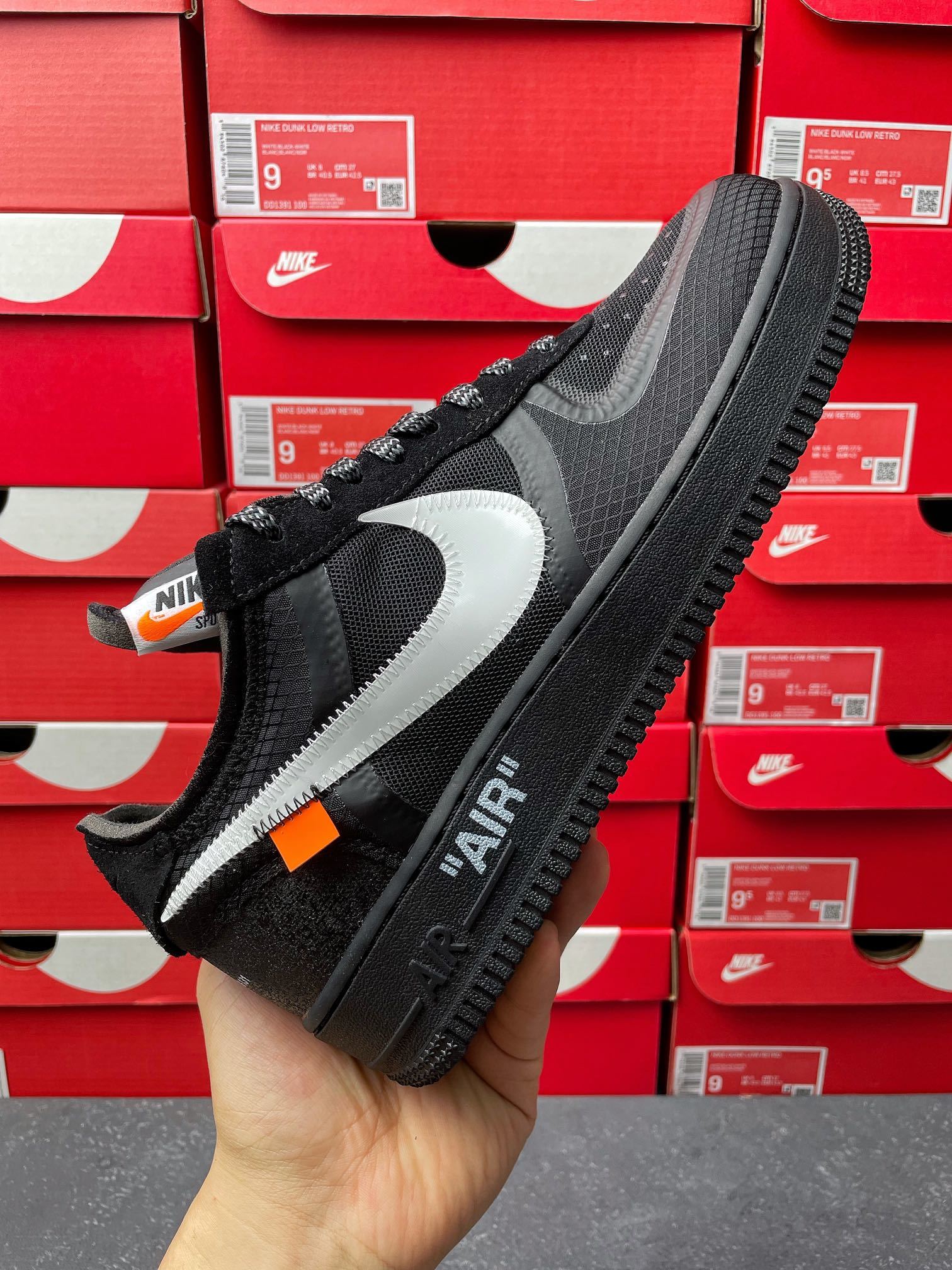 Black low-top mesh sneaker with white swoosh panel and black lace-up, side view