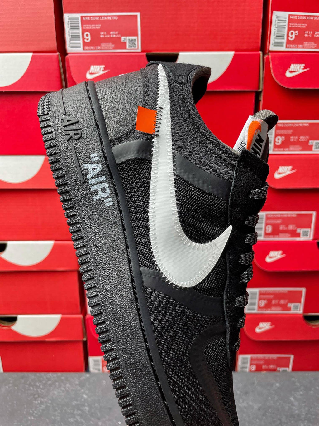 Black Air Force 1 sneaker with white swoosh, mesh upper, lace-up front view