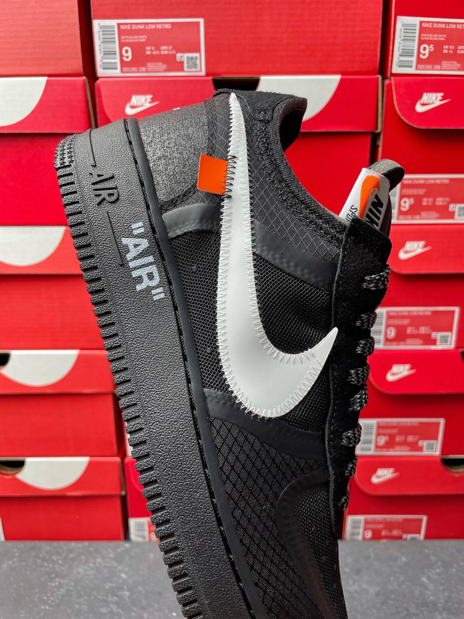 Black Air Force 1 sneaker with white swoosh, mesh upper, lace-up front view
