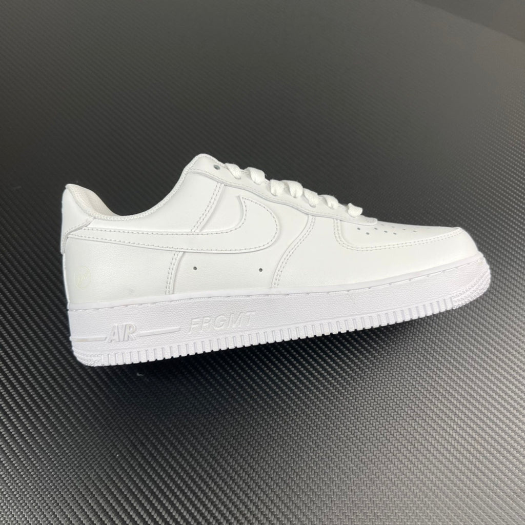 White low-top sneakers with stitched swoosh and lace-up front