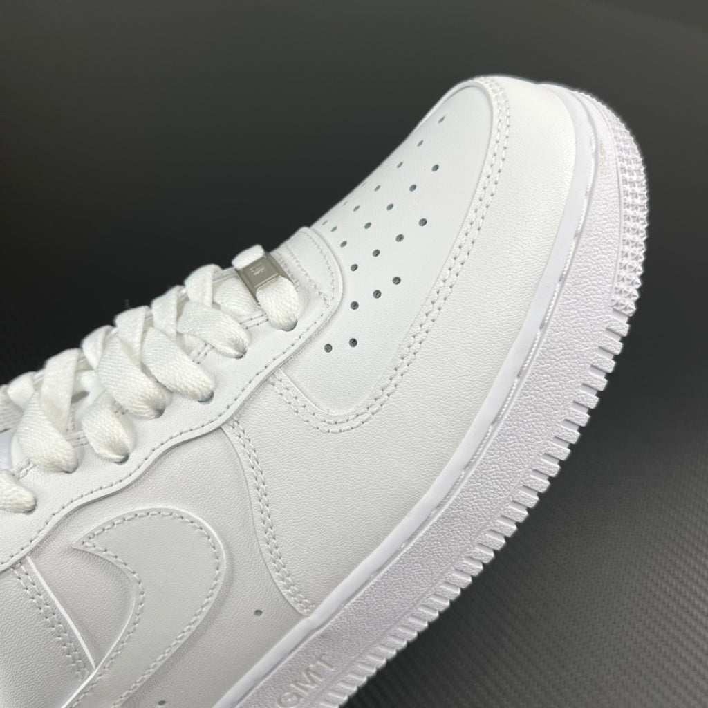 White leather sneakers side view with perforations and lace-up panel