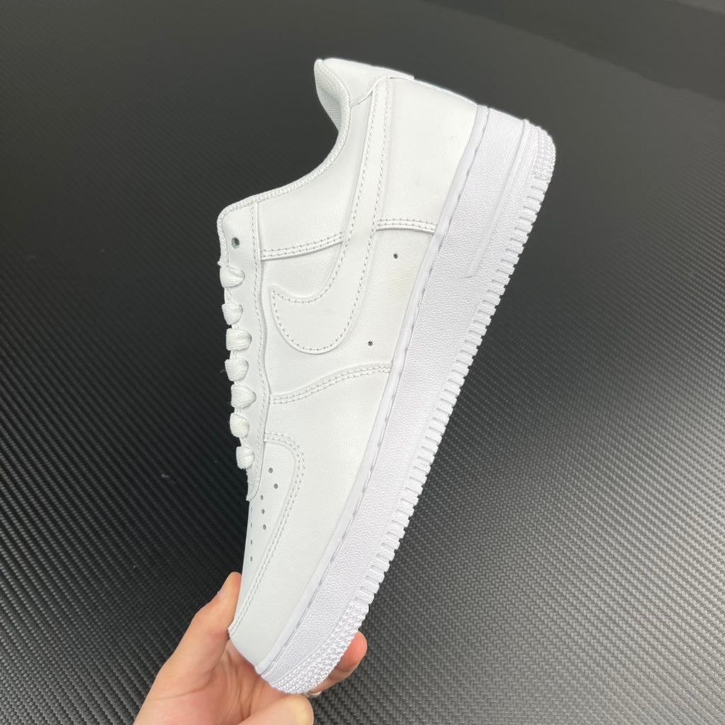 White low-top sneakers held in hand, side profile and textured sole