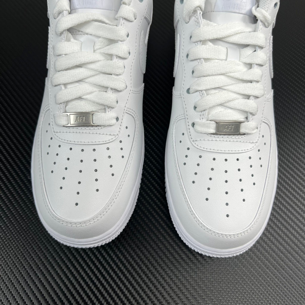 White sneaker front view close-up showing laces, perforations, and logo tab