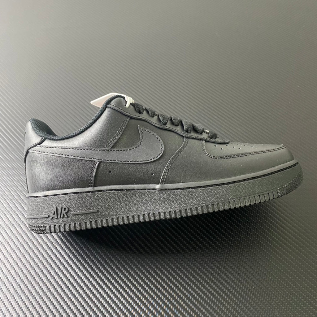 Nike Air Force 1 sneakers in dark leather, black swoosh, lace-up style.