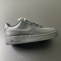 Nike Air Force 1 sneakers in dark leather, black swoosh, lace-up style.