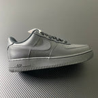 Nike Air Force 1 sneakers in dark leather, black swoosh, lace-up style.