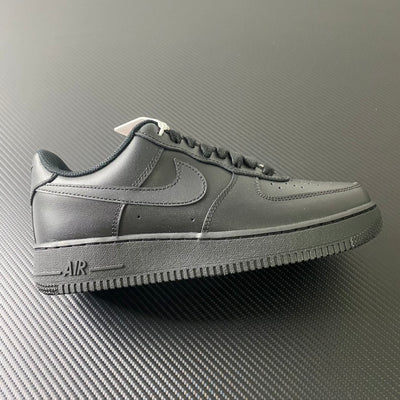 Nike Air Force 1 sneakers in dark leather, black swoosh, lace-up style.