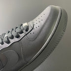 Nike Air Force 1 sneakers, close-up of side panel and perforations, dark leather.