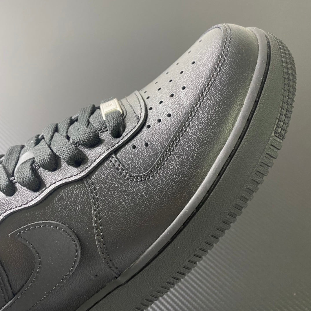 Nike Air Force 1 sneakers, close-up of side panel and perforations, dark leather.