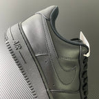 Nike Air Force 1 sneakers, close-up of heel and collar with lace-up closure, dark.