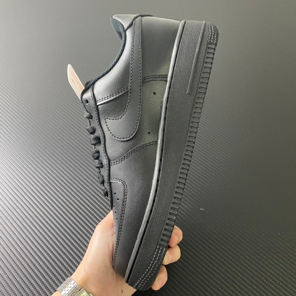 Nike Air Force 1 sneakers, side view with textured outsole, dark leather and swoosh.