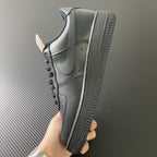Nike Air Force 1 sneakers, side view with textured outsole, dark leather and swoosh.