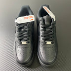 Nike Air Force 1 sneakers pair, front view with perforated toe and lace-up front, dark.