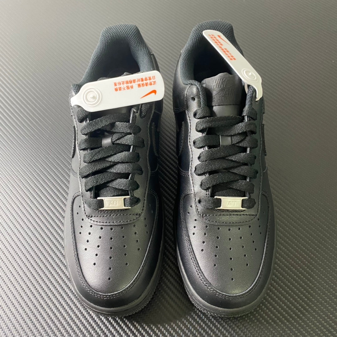 Nike Air Force 1 sneakers pair, front view with perforated toe and lace-up front, dark.