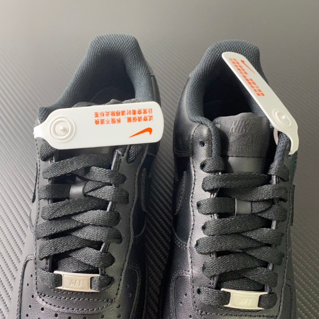 Nike Air Force 1 sneakers pair, back view with heel tab and laces, dark leather.