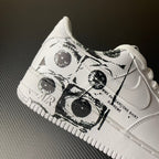 White low-top sneaker with black graphic wrap around laces and swoosh