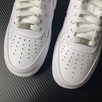 White low-top sneakers with perforations and gold-tone lace bar
