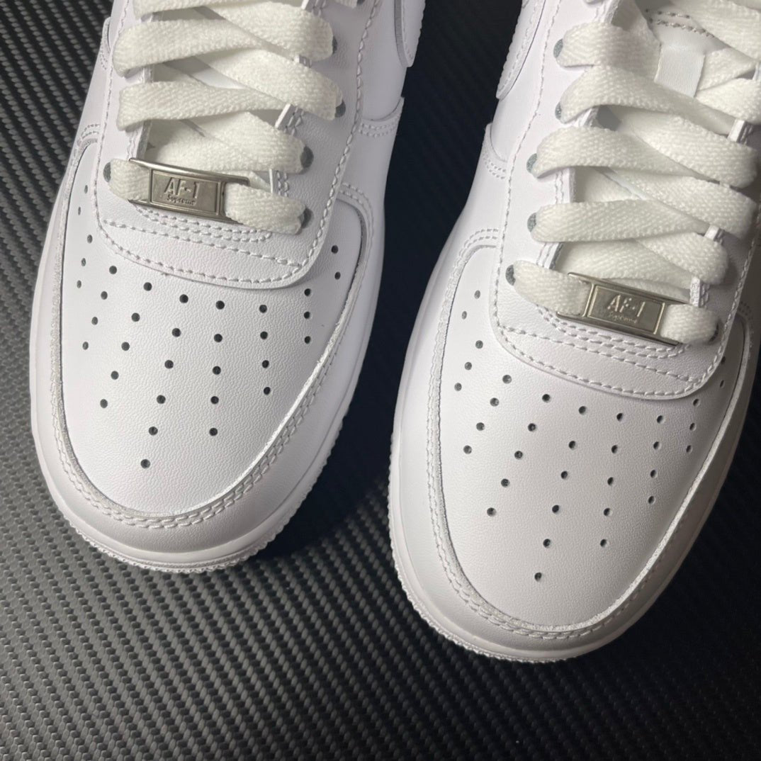 White low-top sneakers with perforations and gold-tone lace bar