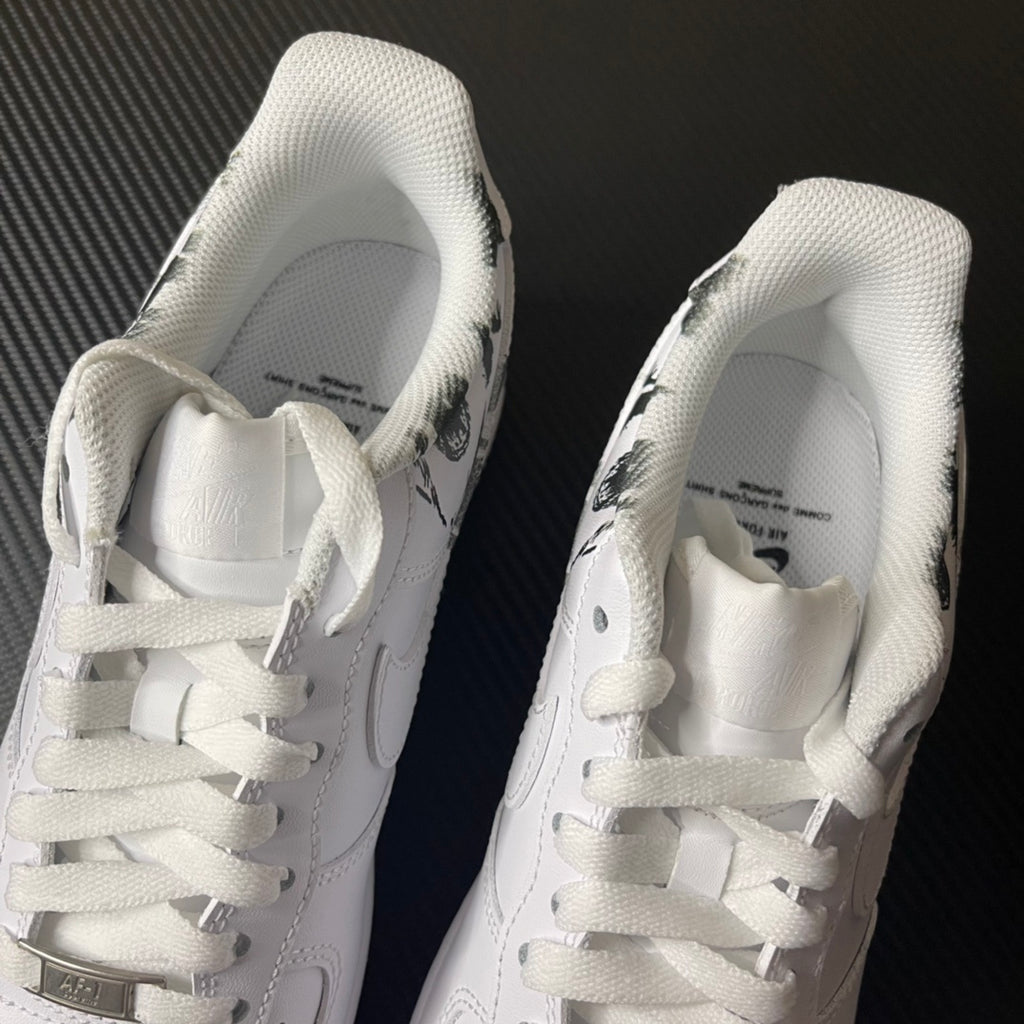 White low-top sneakers with white laces and printed insoles at heel