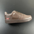 Taupe low-top sneakers with swoosh, lace-up, Supreme patch, and 'AIR' midsole detail.