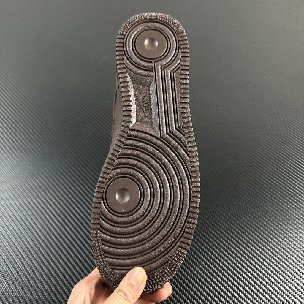Taupe sneaker outsole bottom with circular traction pattern and ridged tread.
