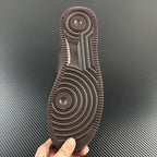 Taupe sneaker outsole bottom with circular traction pattern and ridged tread.