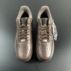 Taupe low-top sneakers front view with lace-up, suede collar, and tongue tags.