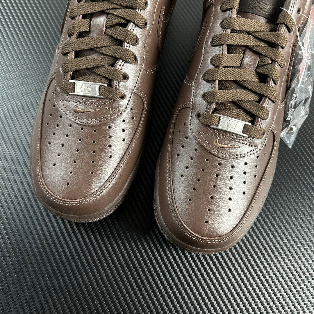 Taupe low-top sneakers top view with lace-up, perforated toe, and side swooshes.