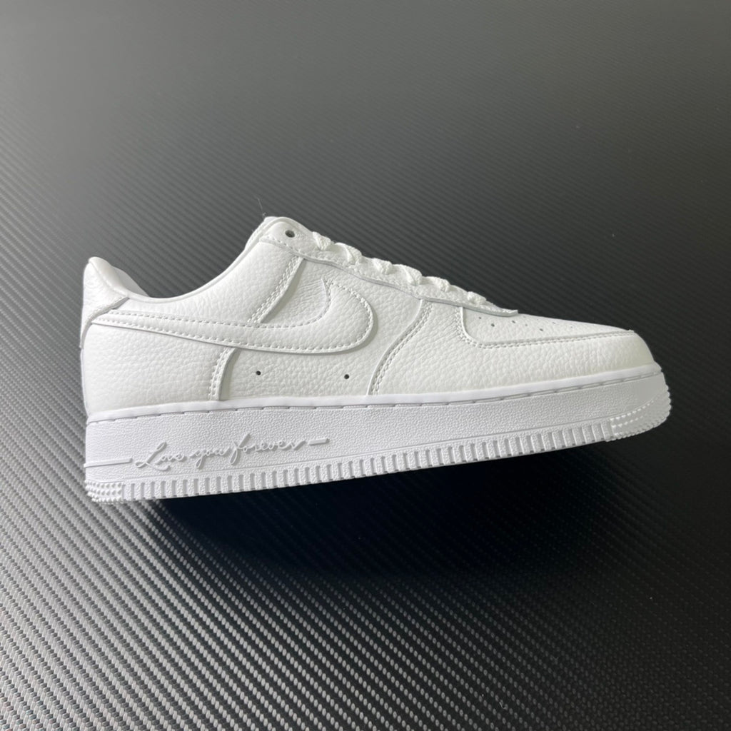 White low-top leather sneakers with swoosh logo and lace-up front