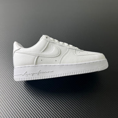 White low-top leather sneakers with swoosh logo and lace-up front