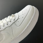White sneaker upper close-up with swoosh, perforations, and laces