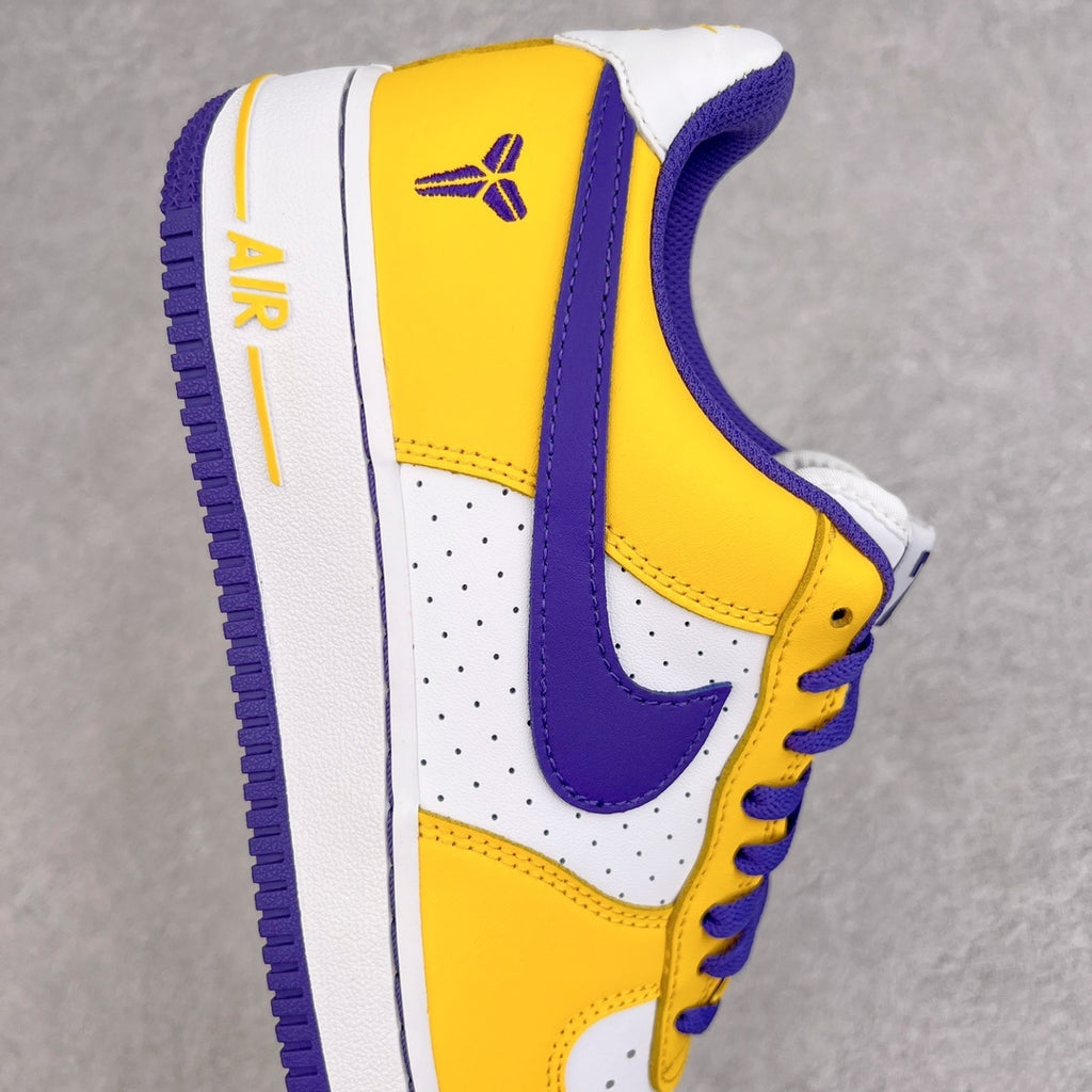 Yellow and white sneaker with purple Nike swoosh, perforated toe, and lace-up