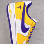 Yellow and white sneaker with purple Nike swoosh, perforated toe, and lace-up