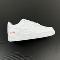 White low-top sneakers with perforated toe and red side Supreme label