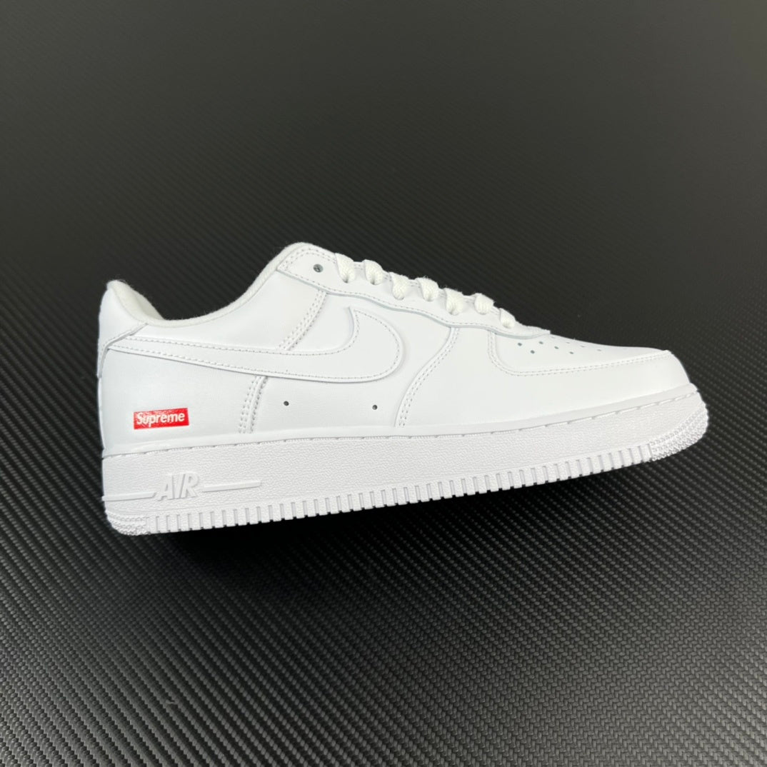 White low-top sneakers with perforated toe and red side Supreme label