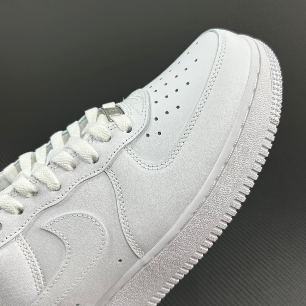 White leather sneakers with Nike swoosh, lace eyelets, and perforated toe