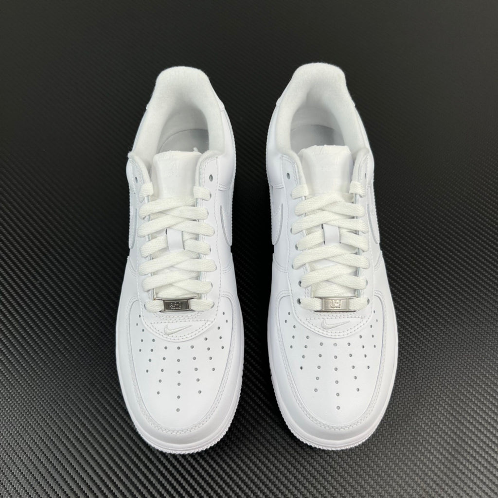 Pair of white low-top sneakers with white laces and perforated toe