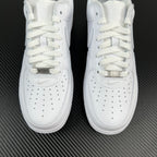 Front view of white low-top sneakers with gold-tone lace tag