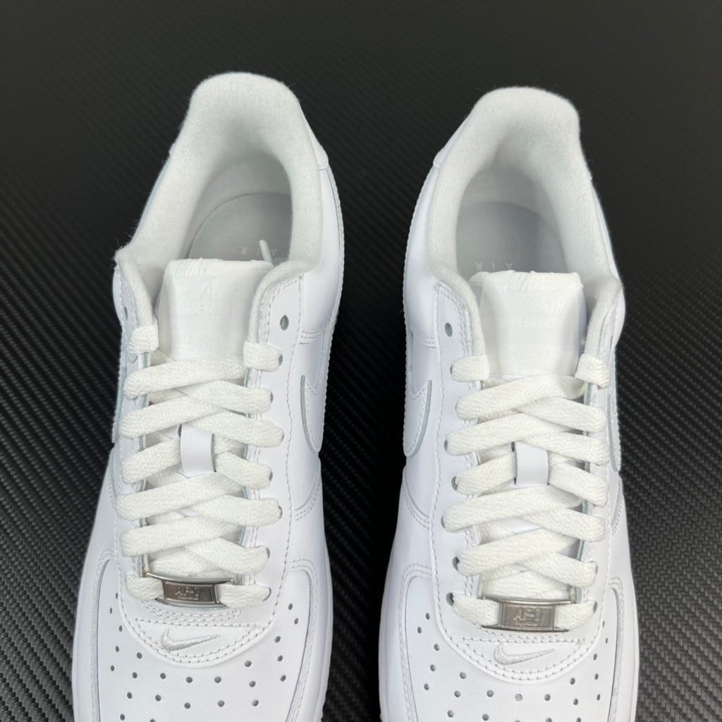 Pair of white sneakers with padded tongue and lace-up front