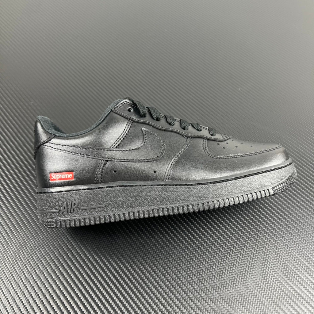 Metallic silver low-top sneakers with Supreme logo on the side and Air text on sole