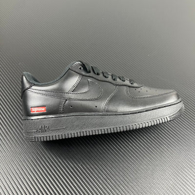 Metallic silver low-top sneakers with Supreme logo on the side and Air text on sole