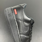 Black leather sneakers with red Supreme label on side and cushioned ankle collar