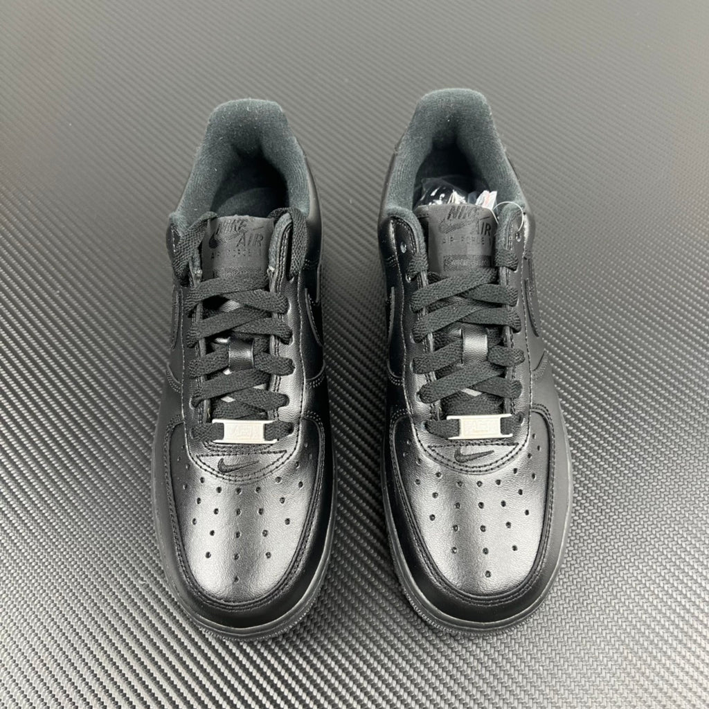 Pair of dark sneakers with lace-up design and perforated toe caps