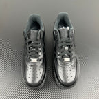 Pair of dark sneakers with lace-up design and perforated toe caps