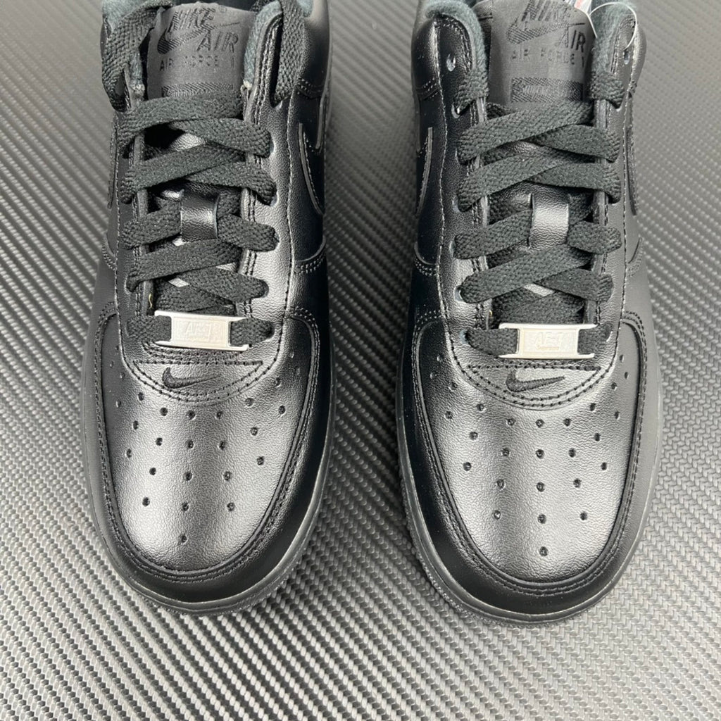 Pair of light gray sneakers with lace-up closure and perforated toe detail